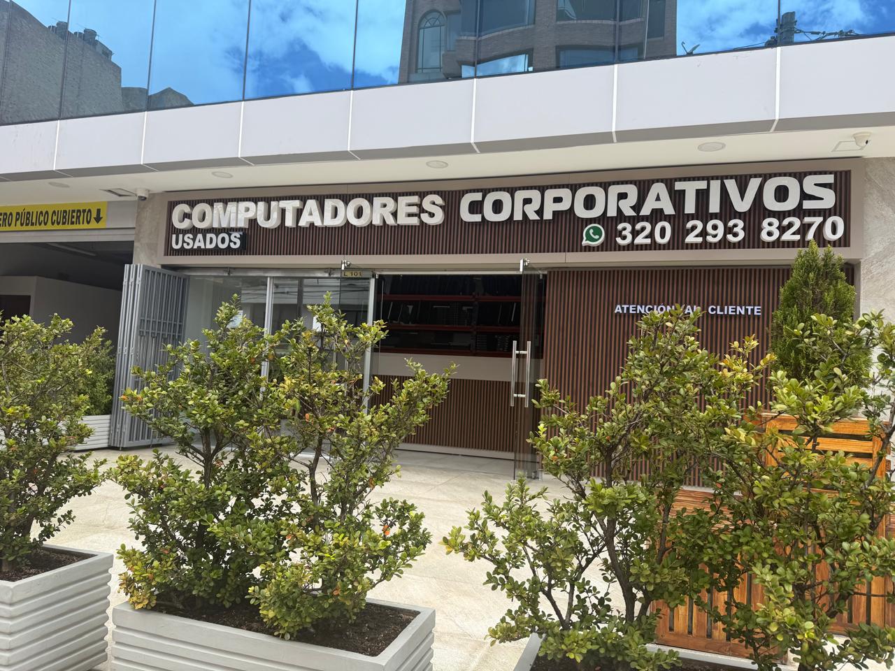 Entrada de atención al cliente en Computadores de Segunda, Carrera 16 Bogotá: vitrina, rótulo corporativo y señalización de WhatsApp.